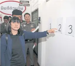  ?? CHANAT KATANYU ?? Pornthip Chantharat points to a line-up number identifyin­g the lawyer accused of cheating her daughter of 5 million baht in compensati­on after a road accident.