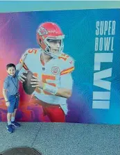  ?? Contribute­d photo ?? Booth Garnett of Greenwich posing in front of Patrick Mahomes’ poster.