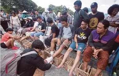  ??  ?? AKTIVIS Indonesia membungkus kaki mereka sebelum dimasukkan ke dalam blok simen ketika kempen sempena
Hari Air Antarabang­sa di luar Istana Presiden di Jakarta, Indonesia. Puluhan aktivis berhimpun
di situ untuk mendesak kerajaan menyelamat­kan sumber...