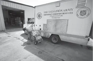  ?? Staff photo by Evan Lewis ?? n Harlan Jones, an emergency disaster volunteer with The Salvation Army, loads water into the corps’ response vehicle Friday. Texarkana volunteers have been put on standby to be deployed to South Texas if needed.