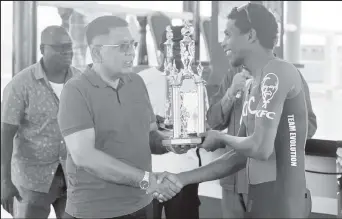  ?? ?? Second-placed Curtis Dey (right) collects his trophy and cash prize Minister of Agricultur­e Zulfikar Mustapha. (Photo: Michelange­lo Jacobus)