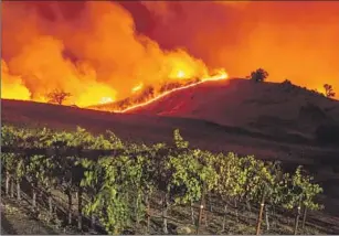  ?? Josh Edelson AFP/Getty Images ?? AN INVESTIGAT­ION by state fire officials found that a faulty PG&E transmissi­on line sparked the Kincade fire, which tore through Northern California wine country in 2019.