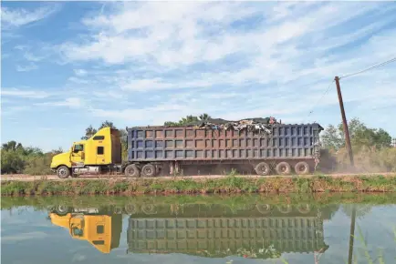  ?? PHOTOS BY ZOE MEYERS/USA TODAY NETWORK ?? A truck drives along the Pacífico Canal toward a dump in the Mexicali Valley.