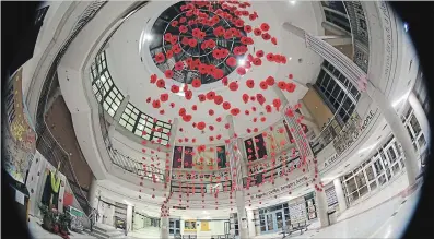  ?? COURTESY OF ANN WEILER ?? Poppies, hand-painted and made from coffee filters, were attached to long streams of fishing line and cascaded down the centre of the bright atrium of St. Benedict Catholic Secondary School in Cambridge.