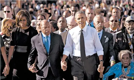  ?? AFP 2015 ?? Then-President Barack Obama walks with, from left, first lady Michelle Obama, U.S. Rep. John Lewis, the Rev. Al Sharpton and original marcher Amelia Boynton Robinson across the Edmund Pettus Bridge to mark the 50th anniversar­y of the Selma to Montgomery civil rights marches in Alabama.