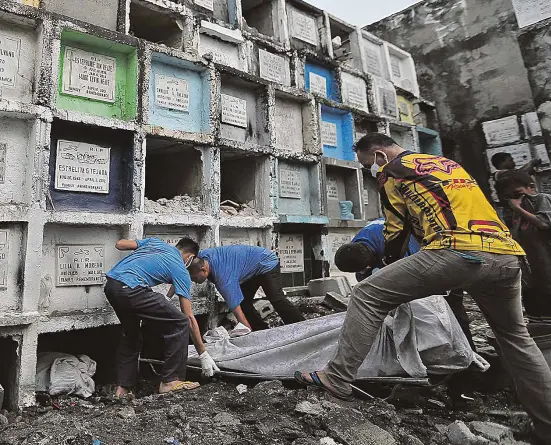  ?? —RAFFY LERMA ?? MASS BURIAL Thirteen victims of executions in the campaign against illegal drugs are buried one on top of the other in tombs at the public cemetery in Navotas City in this photo taken on Jan. 24.