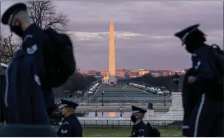  ?? ANDREW HARNIK — THE ASSOCIATED PRESS ?? Members of the U.S. Air Force Honor Guard walk along the west front of the U.S. Capitol on Monday in advance of the Presidenti­al Inaugurati­on with the Washington Monument and the National Mall in the background