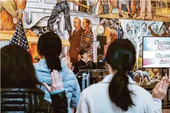  ?? Photos by Felix Uribe/Special to The Chronicle ?? Judge Lisa Cisneros leads the Oath of Allegiance for more than 40 women in front of Diego Rivera’s “Pan American Unity” during a ceremony at the San Francisco Museum of Modern Art.