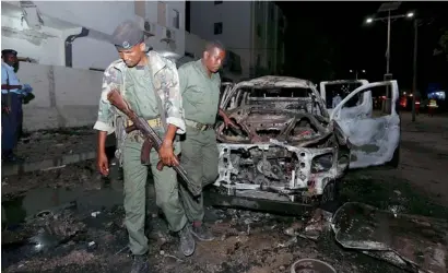  ?? Reuters ?? Somali policemen inspect the scene of the explosion outside a hotel in Somalia’s capital Mogadishu. —