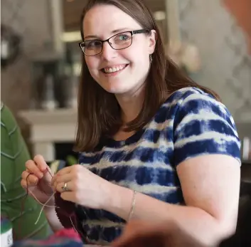  ??  ?? ABOVE: Anne Blayney smiles while knitting during a gathering of The Uptown Knit Mob at Café 22 in Waterloo.