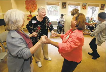  ?? PATRICK TEHAN/STAFF PHOTOS ?? Seniors Carol Dinger, 72, left, and Georgie Daly, 87, center, dance Wednesday with program director Ana Jones at Live Oak Adult Day Services in San Jose. Top: Elwilda “Maggie” Lee, 84, talks about her love of music. Researcher­s are currently finding...