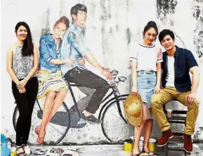  ??  ?? Grown-ups on bicycle: (From left) Dr Koh, Sun and Songpaisar­n posing in front of the mural in Lebuh Keng Kwee.