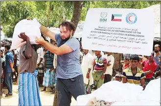  ?? KUNA photo ?? Kuwait Red Crescent Society and IHH Humanitari­an Relief Foundation distribute relief aid to Rohingya refugees
in Bangladesh.