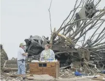  ??  ?? 0 Residents of Oklahoma take a break from cleaning up after tornadoes hit the US and Canada on this day in 2008