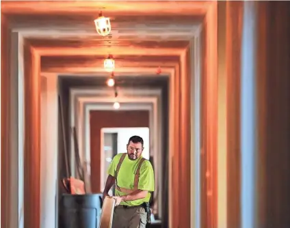  ??  ?? Robert Crouse works on the baseboard and trim molding in apartments at the new Thornwood mixed-use developmen­t on Germantown Road. Constructi­on at the 17-acre, $100 million developmen­t is expected to continue for another 18 months. JIM WEBER/THE COMMERCIAL APPEAL