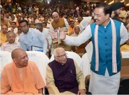  ?? — PTI ?? Uttar Pradesh deputy chief minister Keshav Prasad Maurya shares a light moment with governor Ram Naik and chief minister Yogi Adityanath at a function on completion of one year of the BJP government at Lok Bhawan in Lucknow on Monday.