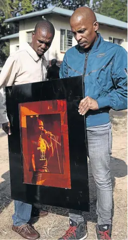  ?? / PHOTOS / SANDILE NDLOVU ?? Ray Phiri’s sons Pholo and Akhona with a portrait of their father.