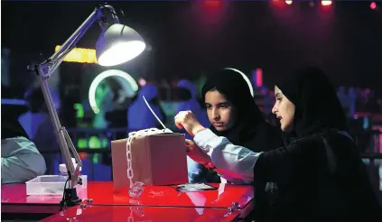  ?? Satish Kumar / The National ?? Rouda Yousef, left, and El Yazi Ismaeil, of Al Maha School, take part in the ‘tamper’ test during the start of the three-day Cyber Quest event and contest at Adnec in Abu Dhabi.