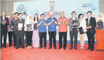  ?? — Bernama photo ?? Hamzah (sixth right) officiates the launch of FIM2018 with KPDNKK Secretary General Datuk Seri Jamil Salleh (seventh left). Hamzah says the franchise industry in Malaysia was on track towards contributi­ng RM35 billion to the national GDP by 2020 on...