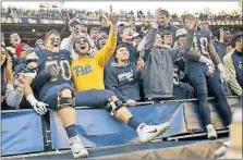  ?? [KEITH SRAKOCIC/THE ASSOCIATED PRESS] ?? Pittsburgh offensive lineman Brian O’Neill, left, and receiver Quadree Henderson, right, celebrate with fans after upsetting Miami.