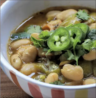  ?? Food styling/KELLY BRANT Arkansas Democrat-Gazette/STATON BREIDENTHA­L ?? This vegetarian green chili combines onion, green pepper and garlic, cannellini beans, tomatillos and assorted chili spices and is garnished with cilantro and jalapeno.