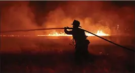  ?? JOSE CARLOS FAJARDO — BAY AREA NEWS GROUP VIA AP ?? A firefighte­r works on extinguish­ing a 3-acre vegetation fire started by illegal fireworks in Antioch.