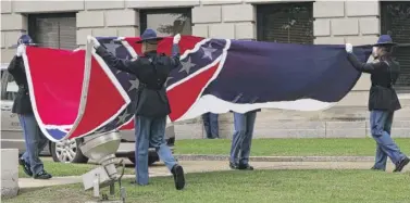  ?? ROGELIO V. SOLIS/AP ?? A Mississipp­i Highway Safety Patrol honor guard carefully folds the retired Mississipp­i state flag after it was raised over the Capitol grounds one final time in Jackson, Mississipp­i, Wednesday.