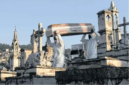  ?? REUTERS ?? Gravedigge­rs carry the coffin of Antonia Rodrigues during her funeral who passed away from the coronaviru­s disease, in Rio de Janeiro, Brazil on May 18.