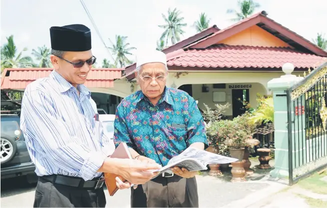  ?? — Gambar Bernama ?? KEPUTUSAN TEPAT: Hussin berbual dengan jirannya Mohd Sabri Alias di hadapan rumahnya di FELDA Lui Timur, Jelebu.