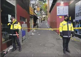  ?? Ahn Young-joon Associated Press ?? OFFICERS stand guard the day after the Oct. 29 disaster in Seoul’s Itaewon district. Too few officers were focused on pedestrian safety, an inquiry found.