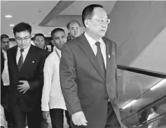  ?? — AFP photo ?? Ri (front) walks towards an escalator for ongoing meetings at the Asean regional security forum in Manila.