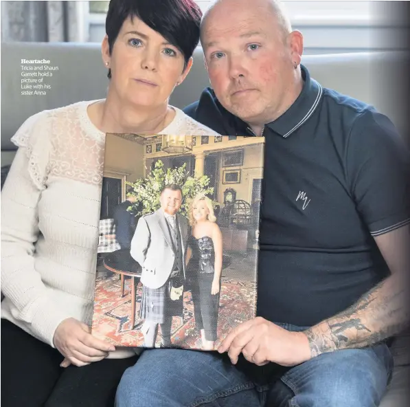  ??  ?? Heartache Tricia and Shaun Garrett hold a picture of Luke with his sister Anna