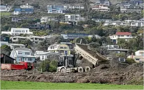  ?? ?? Trucks dump earth from landslides on a site next to Miyazu Gardens, chosen for its accessibil­ity to Atawhai, which experience­d a number of slips.