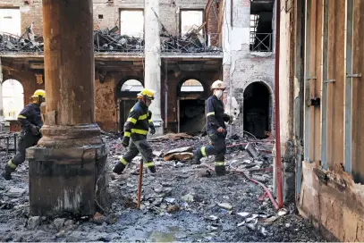  ?? Picture: Reuters ?? AFTERMATH. Firemen walk through the burnt out remains of Jagger Library at the University of Cape Town in Cape Town.