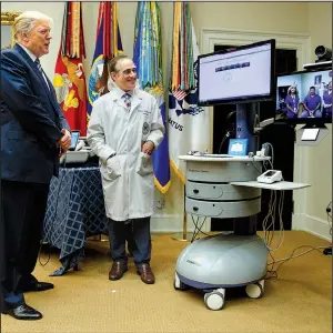  ?? AP/EVAN VUCCI ?? Veterans Affairs Secretary David Shulkin stands with President Donald Trump as Trump talks via technology with a patient during a Veterans Affairs Department “telehealth” event Thursday at the White House. Trump on Thursday criticized Congress over...