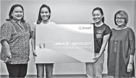  ?? CONTRIBUTE­D PHOTO ?? Representa­tives of Smart and UNHCR pose for a photo during the Infocast training for the disseminat­ion of text updates to displaced Marawi residents.