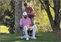  ?? DOUG FERGUSON — THE ASSOCIATED PRESS ?? Scottie Scheffler, seated, gets treatment as he waits to tee off on the 14th hole during the second round of The Players Championsh­ip on Friday in Ponte Vedra Beach, Fla.