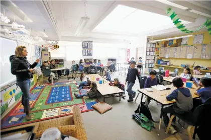  ?? LUIS SÁNCHEZ SATURNO/THE NEW MEXICAN ?? Kim Jones, a third-grade teacher at Amy Biehl Community School, teaches a lesson on maps on Tuesday. Jones got rid of her desks and got tables instead to save space in her classroom.