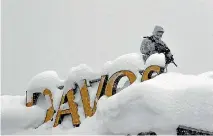  ?? PHOTO: AP ?? An armed Swiss police officer stands guard on the roof of a hotel near the congress centre where the annual meeting of the World Economic Forum is taking place in Davos.