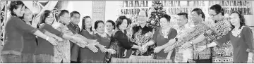  ??  ?? Gerawat (centre) leads in the Christmas cake-cutting ceremony. Julita is at fifth right.