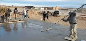  ?? — BRANDON NAHSONHOYA VIA AP ?? people working on a concrete pad for a skateboard­ing ramp in the Village of tewa on the Hopi reservatio­n in northeaste­rn arizona.