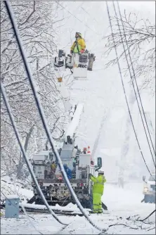  ?? [JULIO CORTEZ/THE ASSOCIATED PRESS] ?? Utility workers use a bucket truck to work on downed power lines amid a winter storm Wednesday in Morristown, N.J.