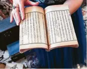  ??  ?? Zhou cherishes an antique book of Chinese characters that she inherited from her late father.