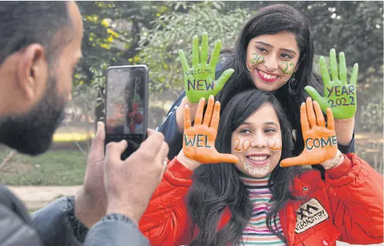  ?? AFP ?? Young women pose for pictures after getting their hands and face painted ahead of New Year’s Eve celebratio­ns in Amritsar, India on Thursday.