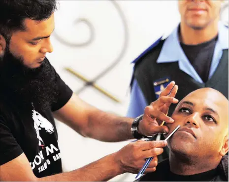  ?? Pictures: TRACEY ADAMS ?? CLEAN SHAVE: Azaad Khan shaves Inspector Ragenald Moos at the Gallows Hill Traffic department in support of Movember.
