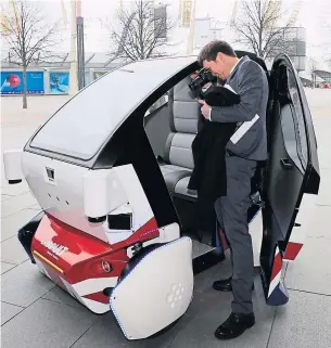  ?? REUTERS ?? A member of the media videotapes the inside of the Lutz Pathfinder (autonomous pod) in Greenwich, east London on Wednesday.