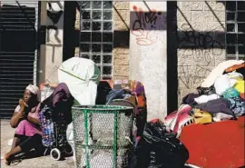  ?? Luis Sinco Los Angeles Times ?? A WOMAN with her belongings on 6th Street in Los Angeles. Tents near shelters in the mayor’s A Bridge Home program would be prohibited under a proposed law.