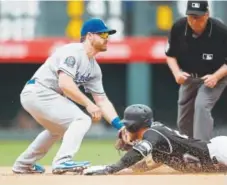  ?? David Zalubowski, The Associated Press ?? Rockies shortstop Trevor Story slides into second base Sunday with a double ahead of the tag by Dodgers second baseman Logan Forsythe as umpire Gerry Davis observes.