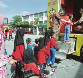  ?? [FOTO MOHD RAFI MAMAT/BH] ?? Kanak-kanak Rumah Anak Yatim Sultanah Hajjah Kalsom melawat ke Balai Bomba dan Penyelamat Jalan Bukit Ubi di Kuantan, semalam.