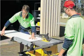  ?? PHOTO: SUPPLIED ?? HELPING HAND: Oakey State High School students Joel Cherry (left) and Ryan Weber help with the constructi­on of a storage facility at Oakey TOMnet.